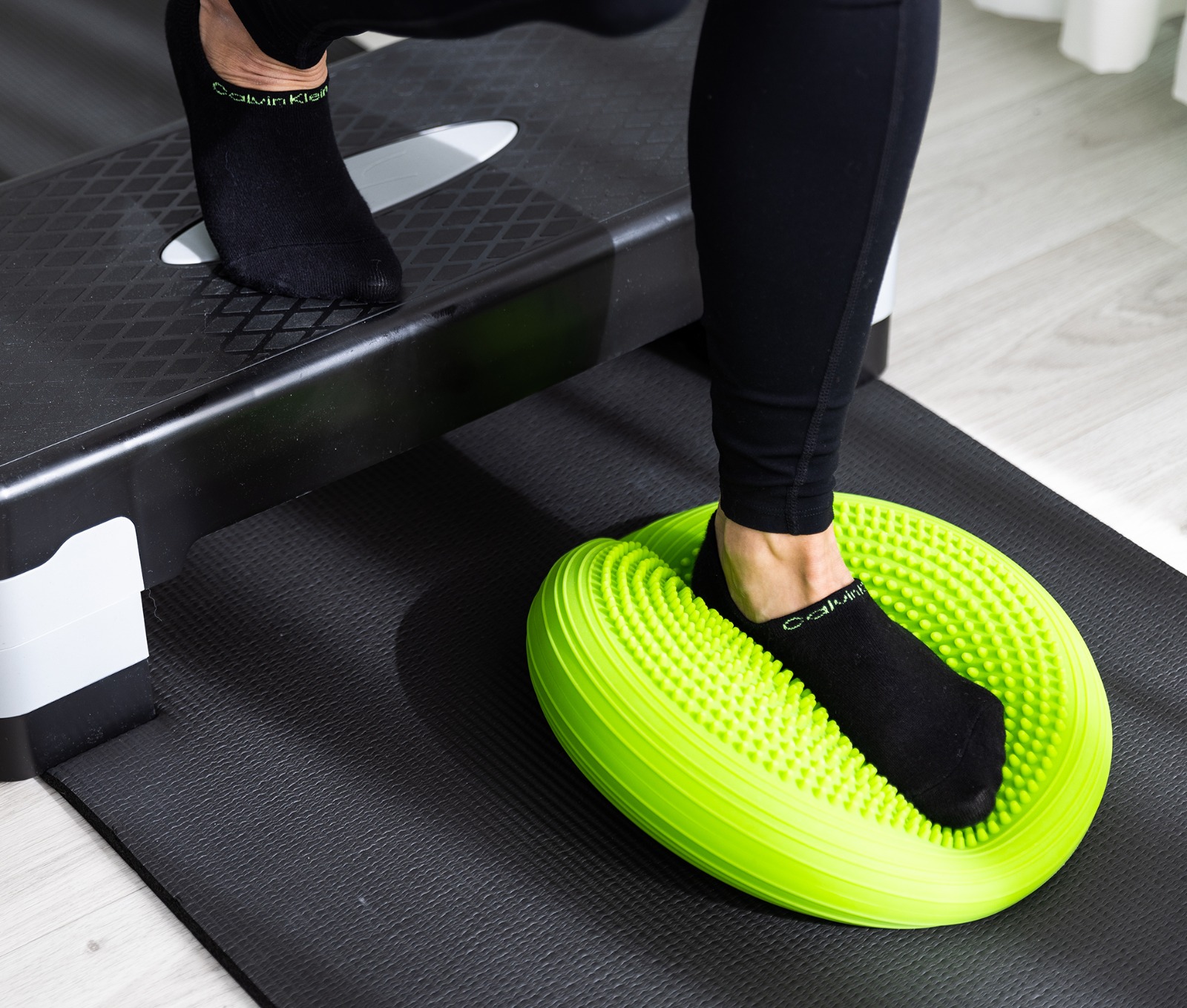 Fußtraining auf einem grünen Balancekissen bei EkaPhysio